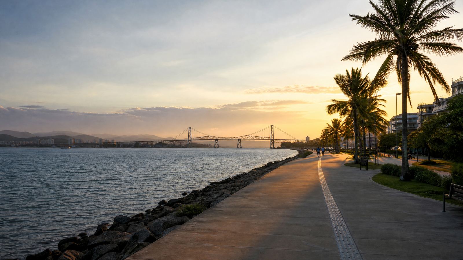 A Beira-Mar Norte ao entardecer, com o calçadão, palmeiras e a ponte ao fundo.