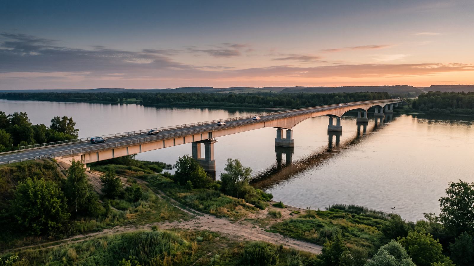 Un puente internacional largo sobre un río ancho al amanecer.